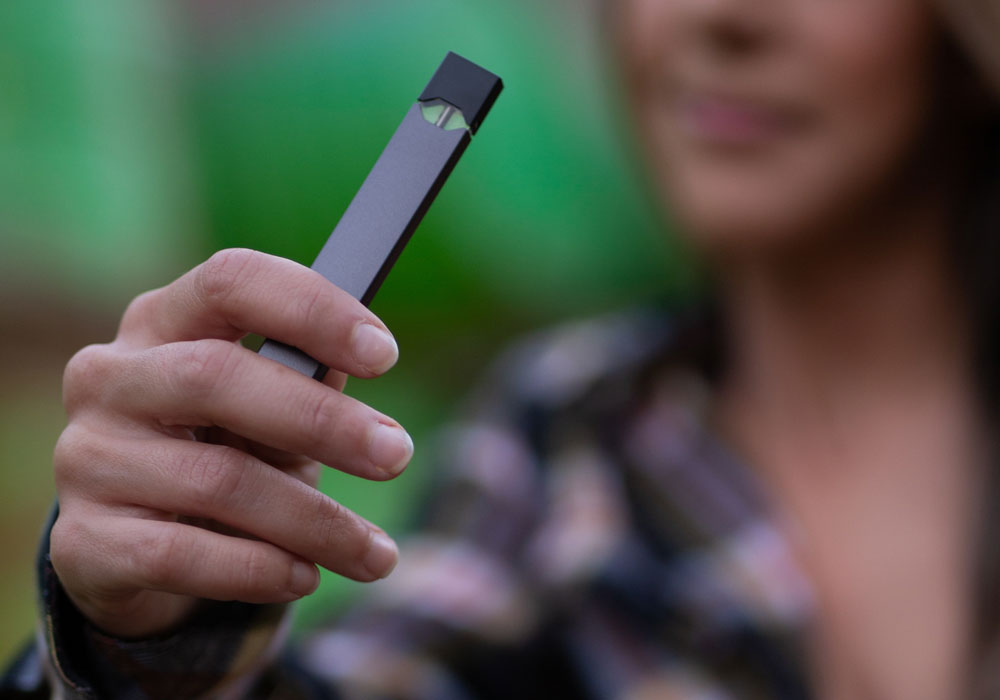 female hand holding a vaping device