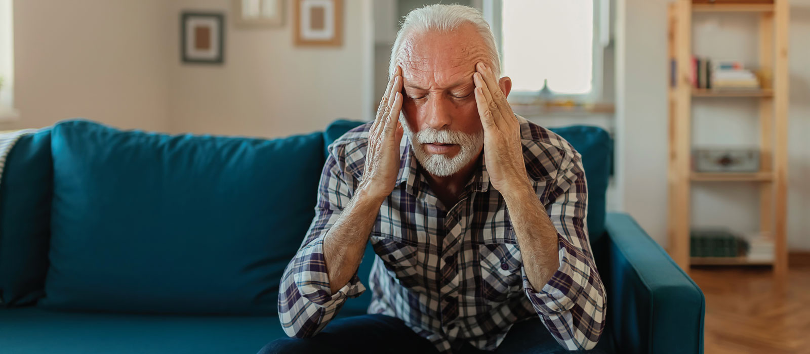 male patient holding his head in his hands